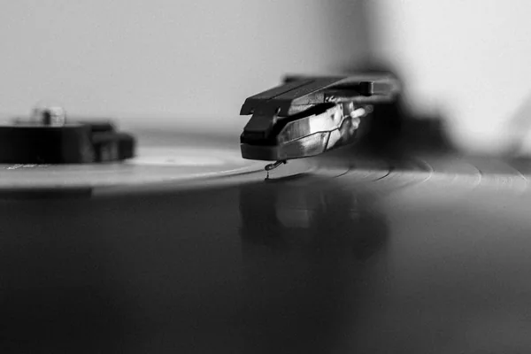 Gros plan sur la pointe de lecture diamant d'une platine posée dans le sillon d'un vinyle