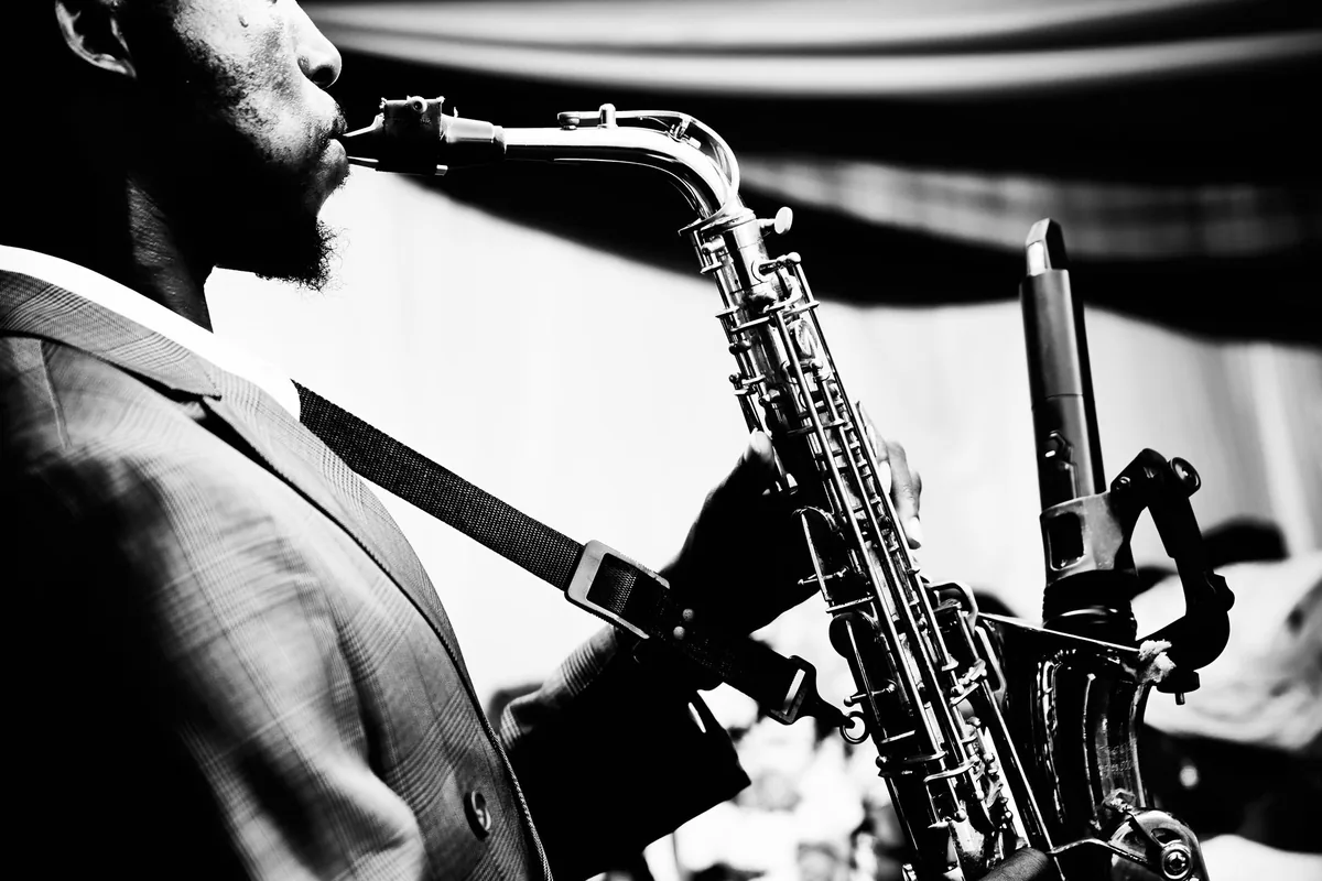 Saxophoniste de jazz jouant sur scène dans un club en noir et blanc