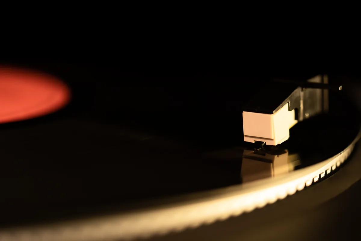 Gros plan sur les sillons d'un disque vinyle sous la pointe de lecture