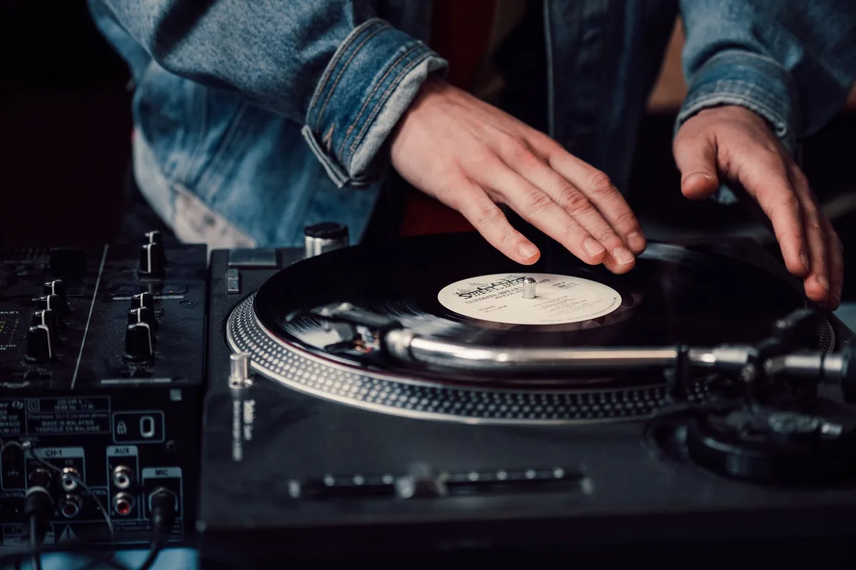 DJ mixant des vinyles maxi 45 tours sur deux platines avec une table de mixage