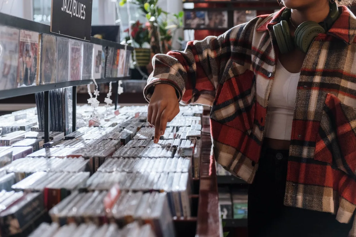 Collectionneur feuilletant des vinyles classés par genre dans un bac