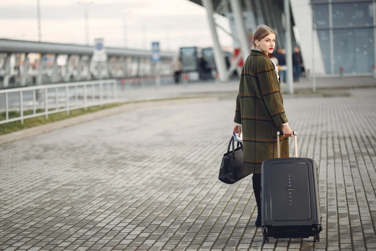 Bagage cabine et sac à dos dans un aéroport, idéal pour transporter des vinyles en avion