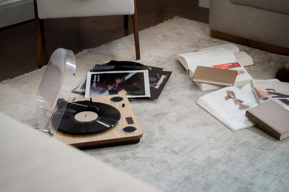 Platine vinyle posée sur un meuble, capot ouvert, dans un intérieur lumineux