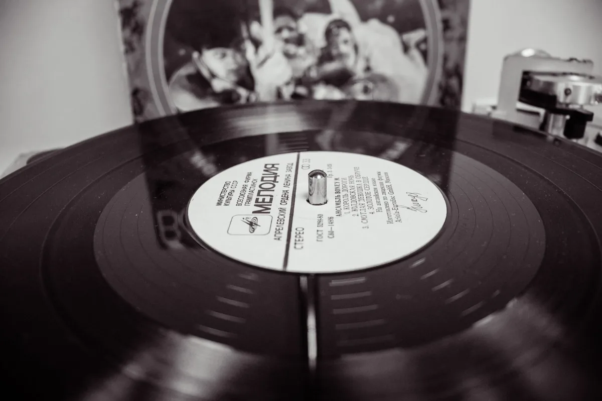 Vinyle coloré splatter multicolore sorti de sa pochette sur une platine