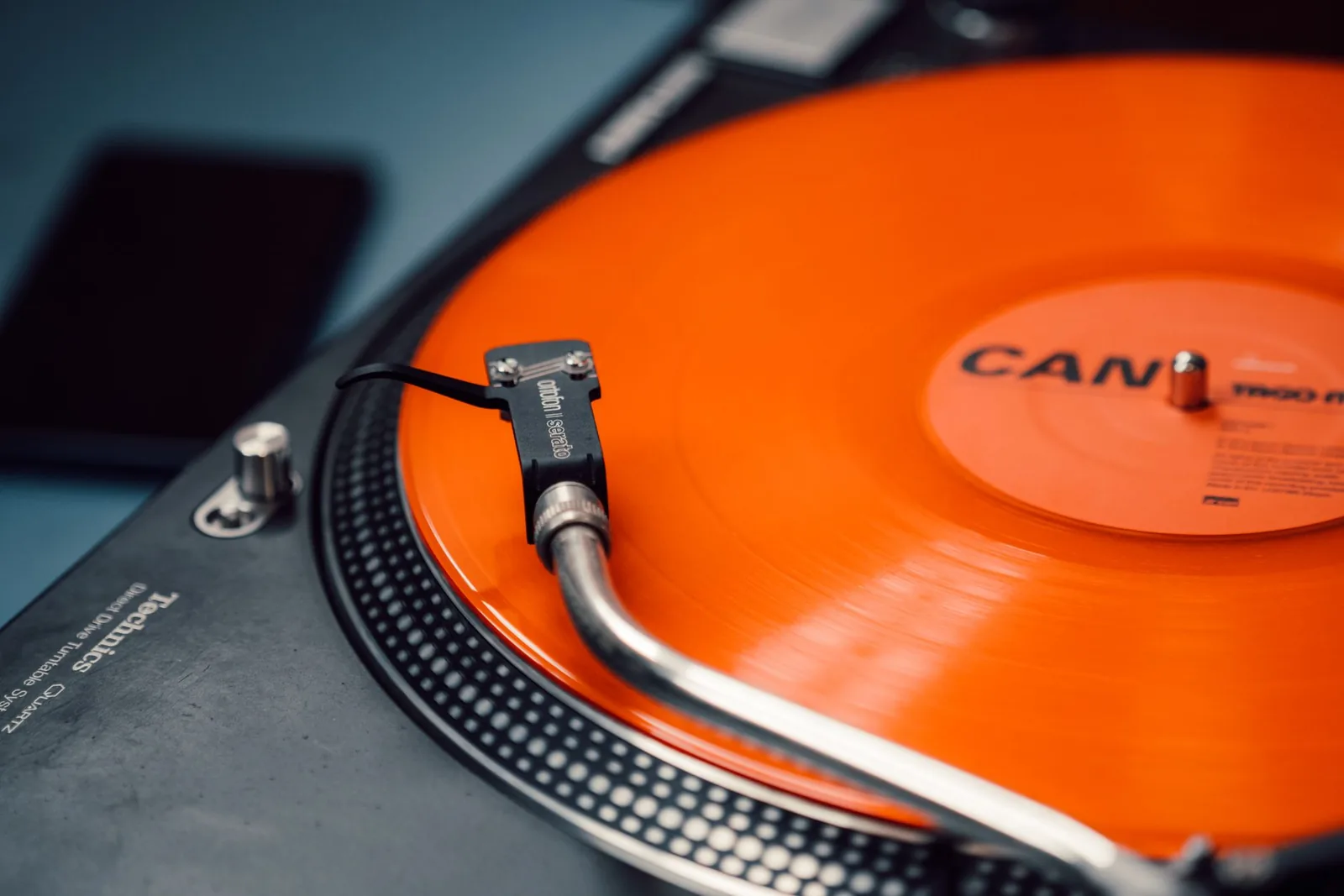 Vinyle coloré translucide posé sur une platine, reflets de lumière